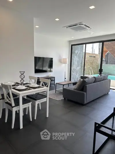 Modern living room with sleek furniture and pool view, perfect for stylish urban living.