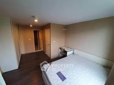 Spacious bedroom with modern design and ample natural light, featuring a comfortable bed and sleek flooring.