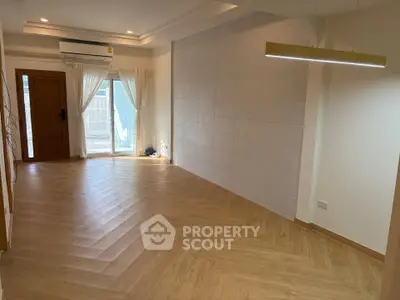 Spacious empty living room with wooden flooring and large window