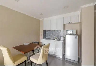 Cozy kitchen with dining area, featuring white cabinets and modern appliances.