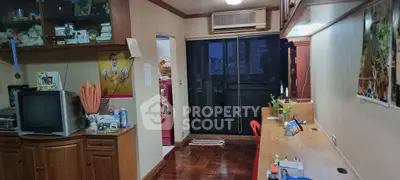 Cozy living space with wooden flooring and built-in storage, featuring a sliding glass door to balcony.