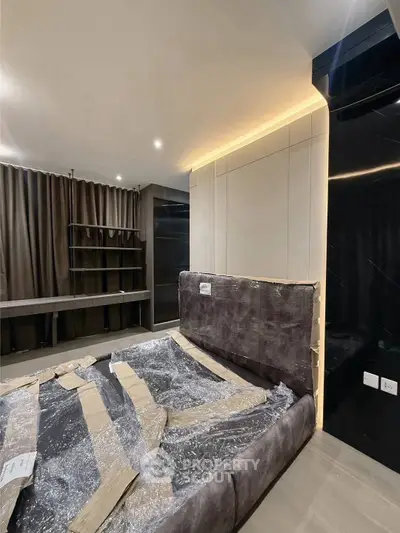 Modern bedroom with sleek design and ambient lighting, featuring a large bed and stylish shelving.