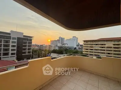 Spacious balcony with stunning city view at sunset, perfect for relaxation.