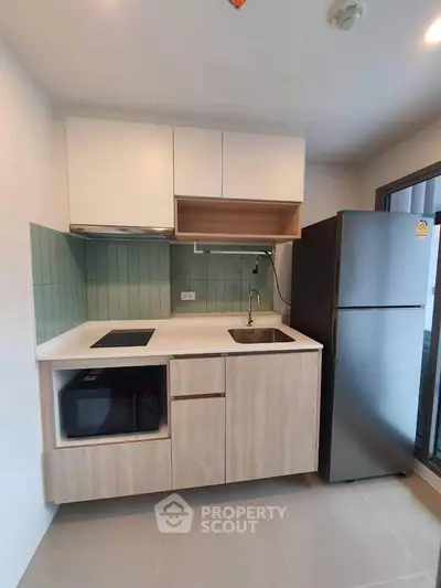 Modern kitchen with sleek appliances and stylish cabinetry in a compact layout.