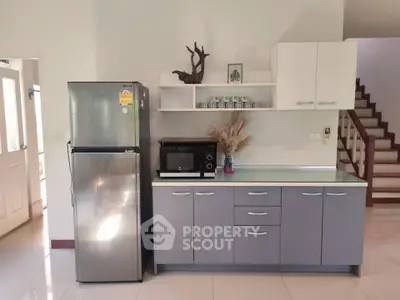 Modern kitchen with sleek cabinets, stainless steel fridge, and stylish decor