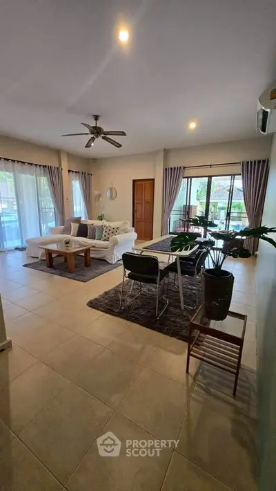 Spacious living room with modern decor and large windows offering natural light.
