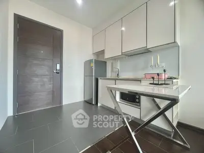 Modern kitchen with sleek cabinets, stainless steel appliances, and stylish dining table in a compact layout.