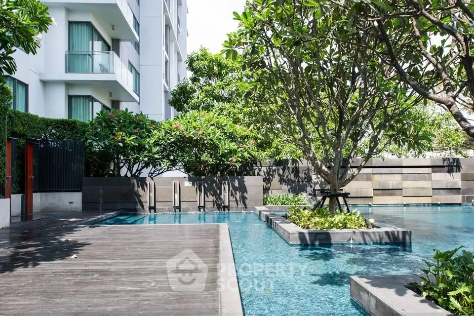 Luxurious residential pool area with lush greenery and modern design, perfect for relaxation and leisure.