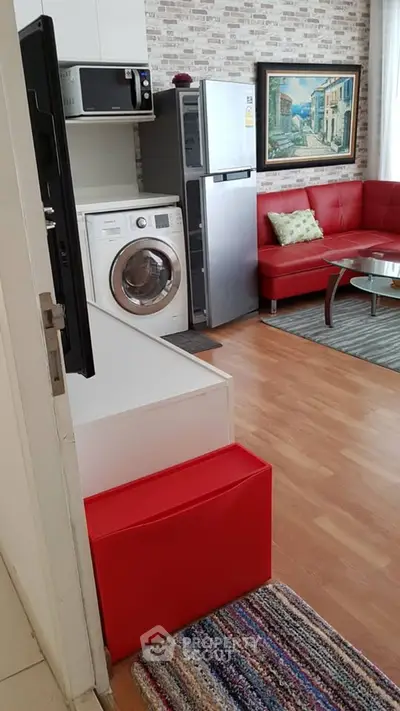 Modern living room with red sofa, washing machine, and stylish decor