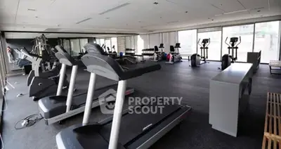 Spacious modern gym with state-of-the-art equipment and large windows.