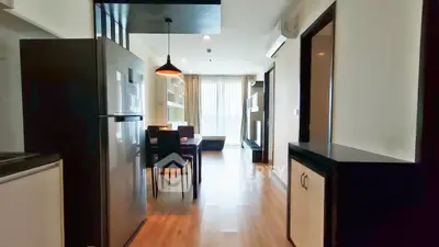 Modern apartment interior with open layout, featuring a sleek kitchen and cozy living area with natural light.