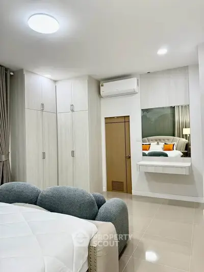 Modern bedroom with sleek design, featuring built-in wardrobes and cozy bed.