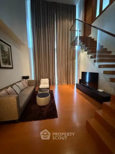 Luxurious living room with high ceilings and elegant staircase