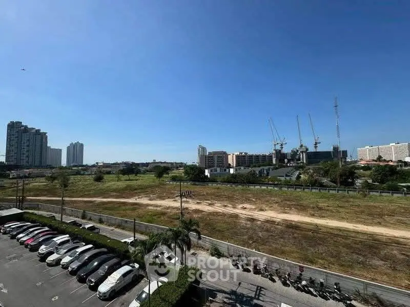 Expansive urban view with construction cranes and parking area, ideal for future development opportunities.