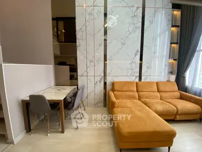 Luxurious modern living room with marble accents and stylish orange sofa