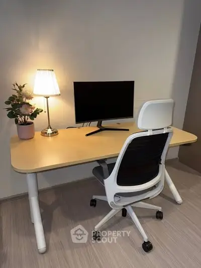 Modern home office setup with sleek desk, ergonomic chair, and stylish lamp for productive work environment.