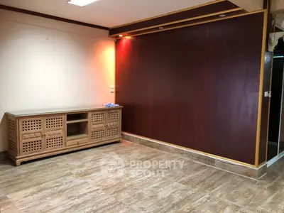 Spacious empty room with elegant wooden cabinet and warm lighting