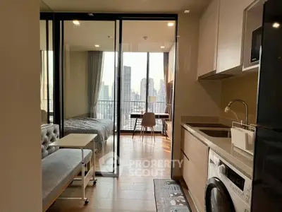 Modern apartment with open kitchen and city view, featuring a washing machine and stylish decor.