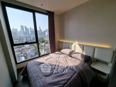 Modern bedroom with city view, featuring cozy bedding and large window for natural light.
