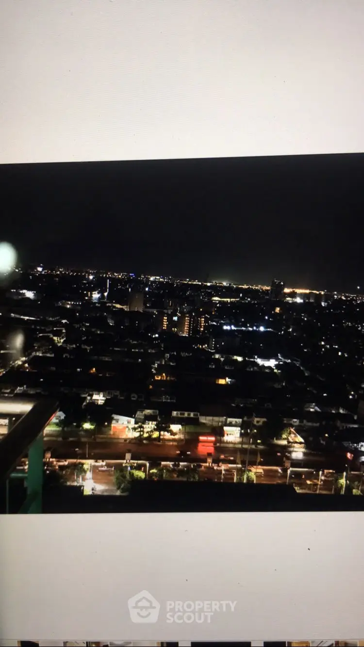 Stunning city skyline view at night from a high-rise balcony, showcasing vibrant urban lights.
