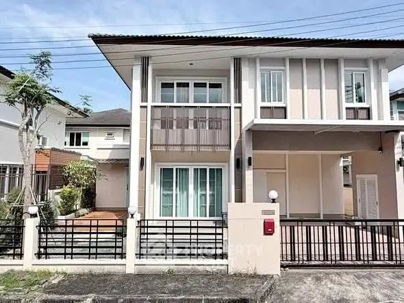 Modern two-story house with sleek design and spacious balcony in a suburban neighborhood.