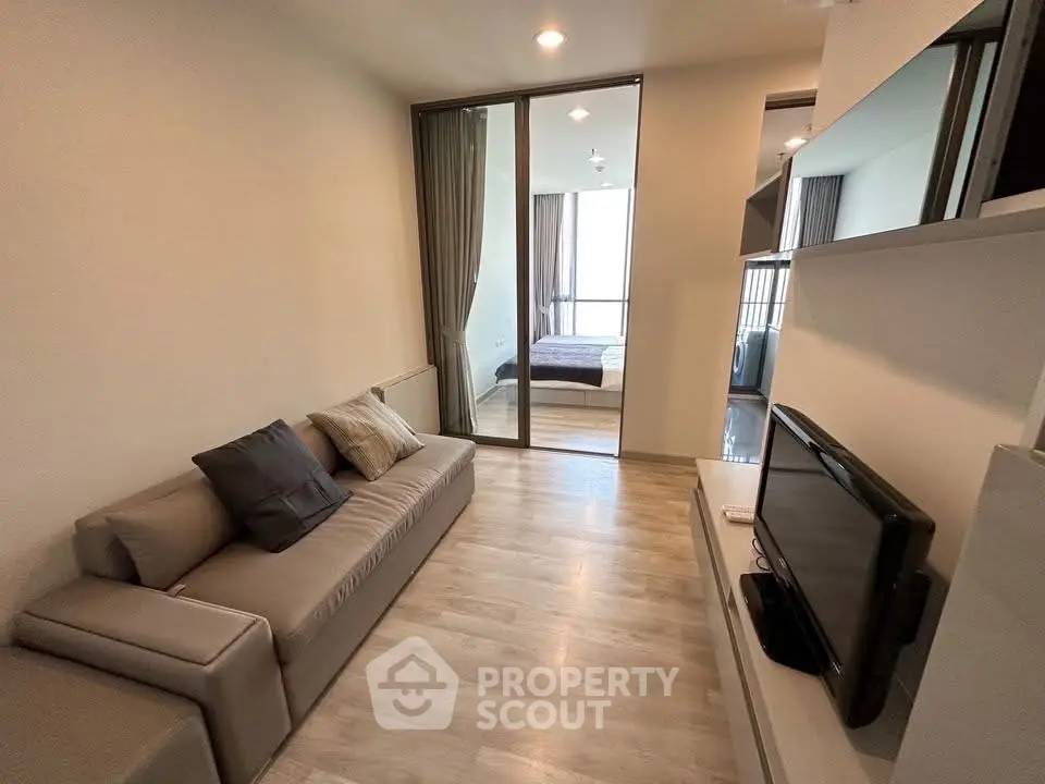 Modern living room with sleek design and cozy ambiance, featuring a comfortable sofa and flat-screen TV.
