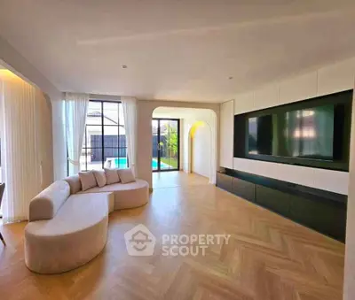 Spacious modern living room with large TV and elegant curved sofa