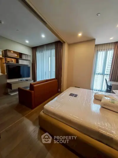 Modern studio apartment with open layout, featuring a cozy living area and a comfortable bed.