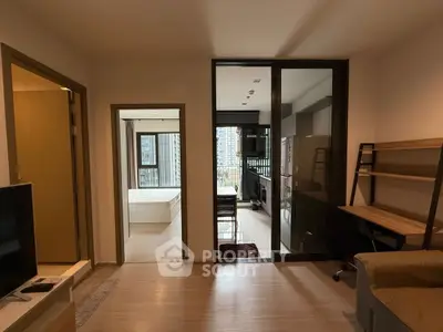Modern apartment interior with open kitchen and cozy living space, featuring a view of the city skyline.