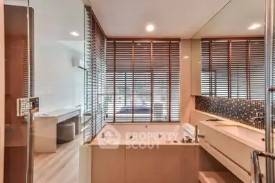 Luxurious bathroom with modern design and spacious bathtub, featuring elegant wooden blinds.