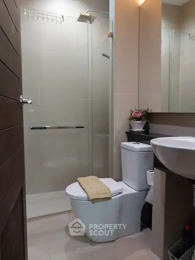 Modern bathroom with glass shower, sleek fixtures, and elegant decor.