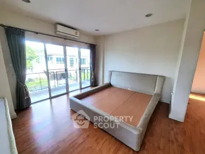 Spacious bedroom with large windows and balcony access in modern apartment