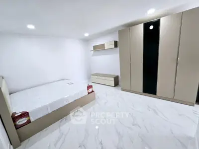 Spacious modern bedroom with sleek furniture and marble flooring