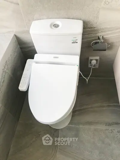 Modern bathroom with sleek toilet and bidet feature, showcasing contemporary design and functionality.