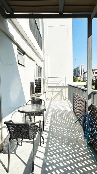 Spacious balcony with outdoor seating and city view, perfect for relaxation.
