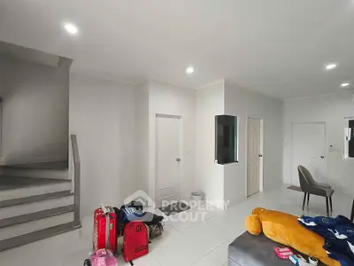 Modern living room with staircase and minimalist decor, ideal for contemporary urban living.