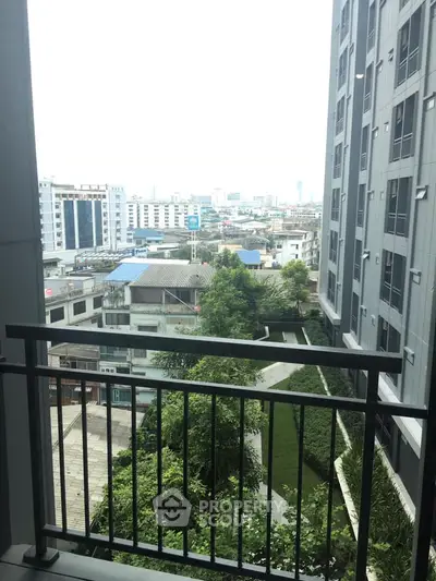Urban apartment balcony with city view and lush greenery