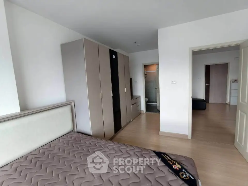 Spacious bedroom with modern wardrobe and ensuite bathroom in a stylish apartment.