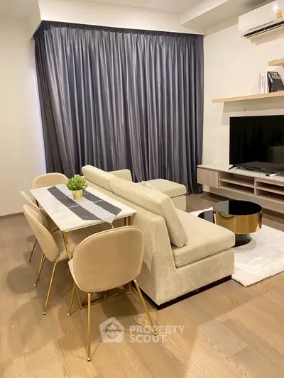 Modern living room with elegant dining set and cozy sofa, featuring stylish decor and a sleek entertainment unit.