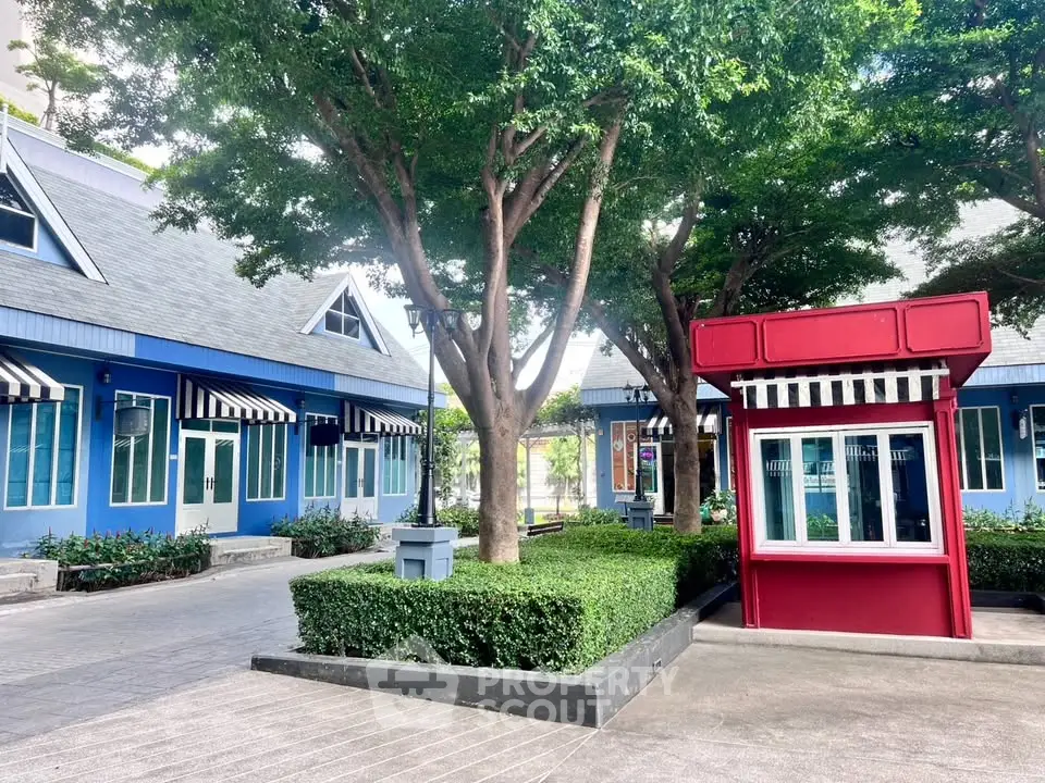 Charming courtyard with blue buildings and lush greenery, perfect for a serene urban retreat.