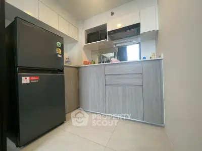 Modern compact kitchen with sleek cabinetry and appliances in a stylish apartment.