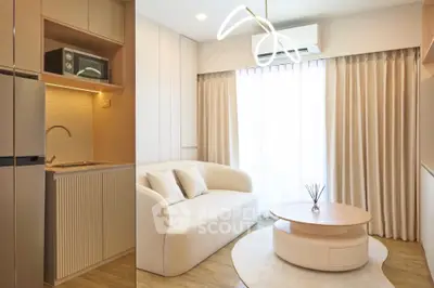 Modern living room with cozy sofa, stylish coffee table, and compact kitchen area featuring microwave and fridge.