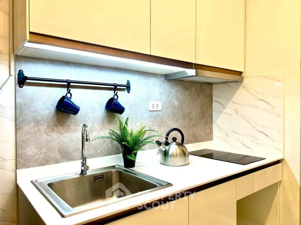 Modern kitchen with sleek cabinetry, induction cooktop, and stylish backsplash, perfect for contemporary living.