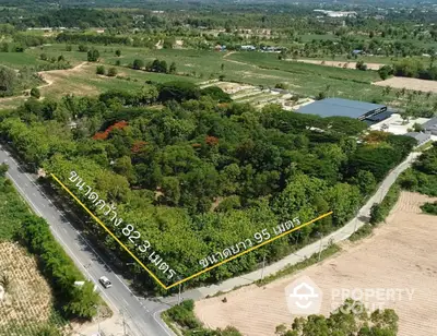 Expansive aerial view of lush green land plot with road access, ideal for development opportunities.