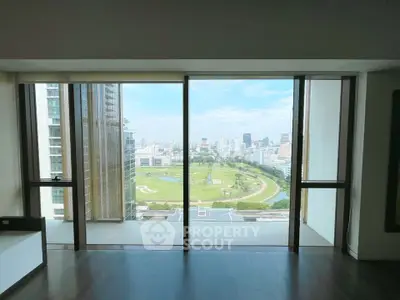 Spacious living room with floor-to-ceiling windows offering a stunning cityscape view.