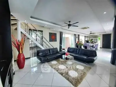 Spacious modern living room with sleek black sofas and elegant decor