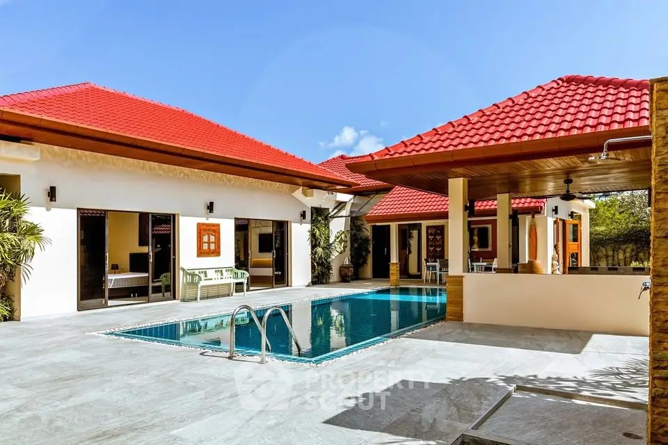 Luxurious villa with red roof and private pool under clear blue sky