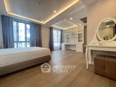 Spacious bedroom with elegant lighting and built-in study area, perfect for modern living.