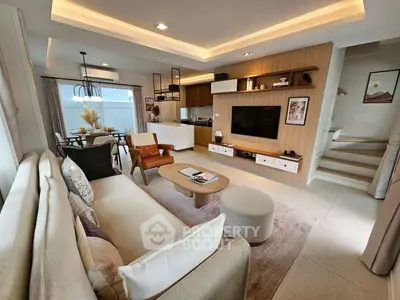 Modern open-layout living room with stylish furniture and integrated kitchen area, perfect for contemporary living.