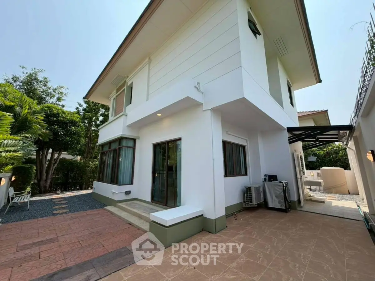 Spacious modern two-story house with large windows and outdoor patio in a serene neighborhood.